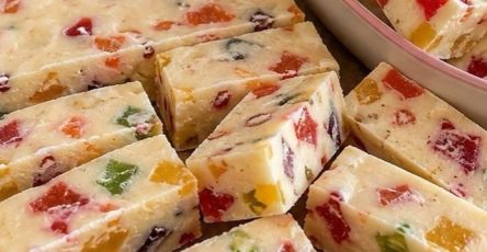 Close-up of several homemade soft torrone bars, showcasing the creamy white nougat embedded with blanched almonds.